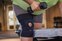 Close up of woman at gym lifting weights, wearing Actimove Sports Edition Knee Support Adjustable in plus size
