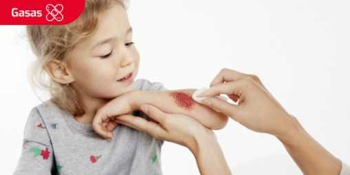 Una imagen de una niña dónde le curan una herida